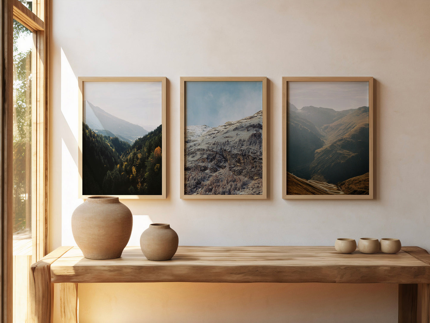 Three framed analog photographs from the Between series hanging on a wall. From left to right: Between Forests, Between Seasons, and Between Valleys.