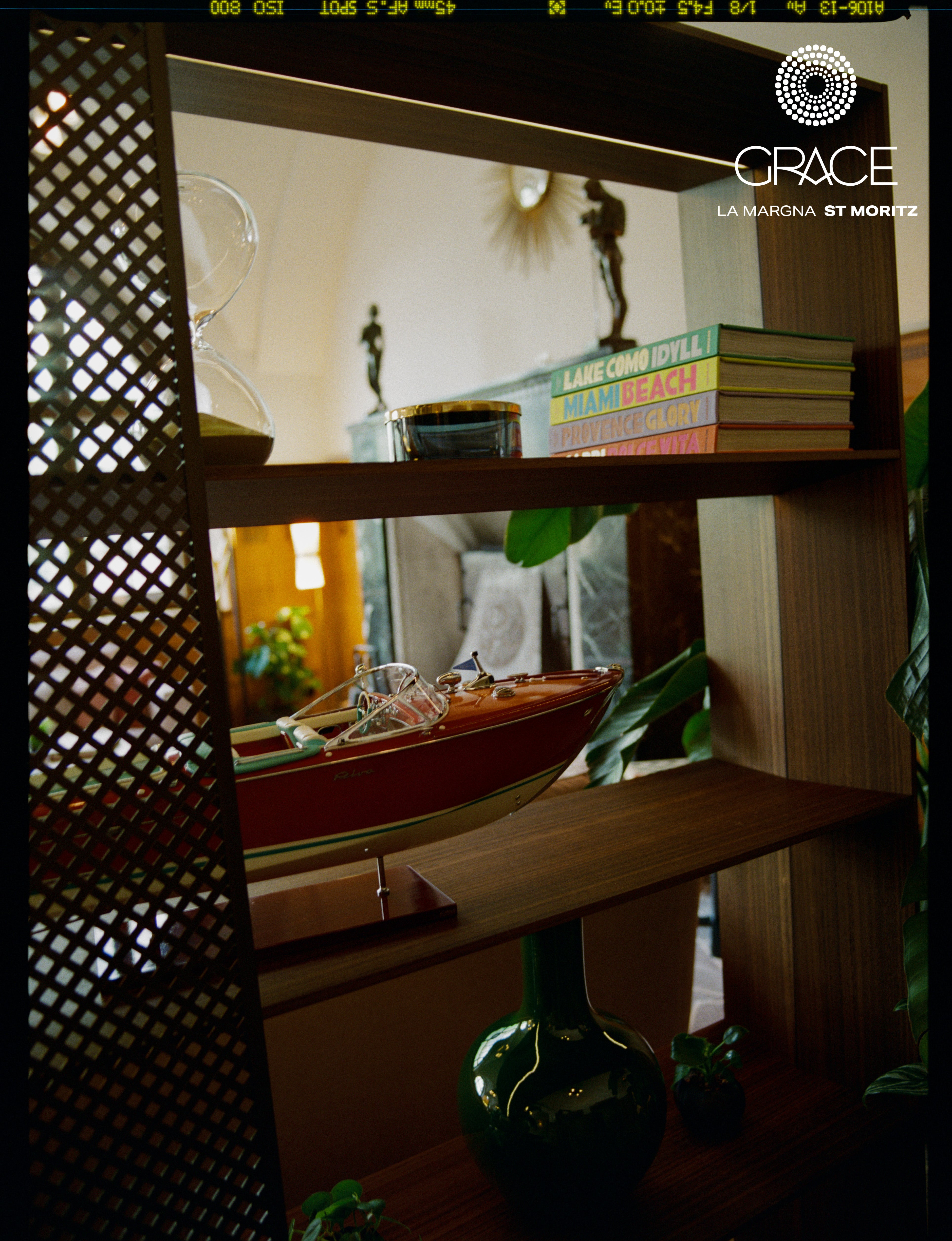 Analog interior still life of wooden shelving with books, decor objects, and model boat at Grace La Margna in St Moritz, shot on medium format film