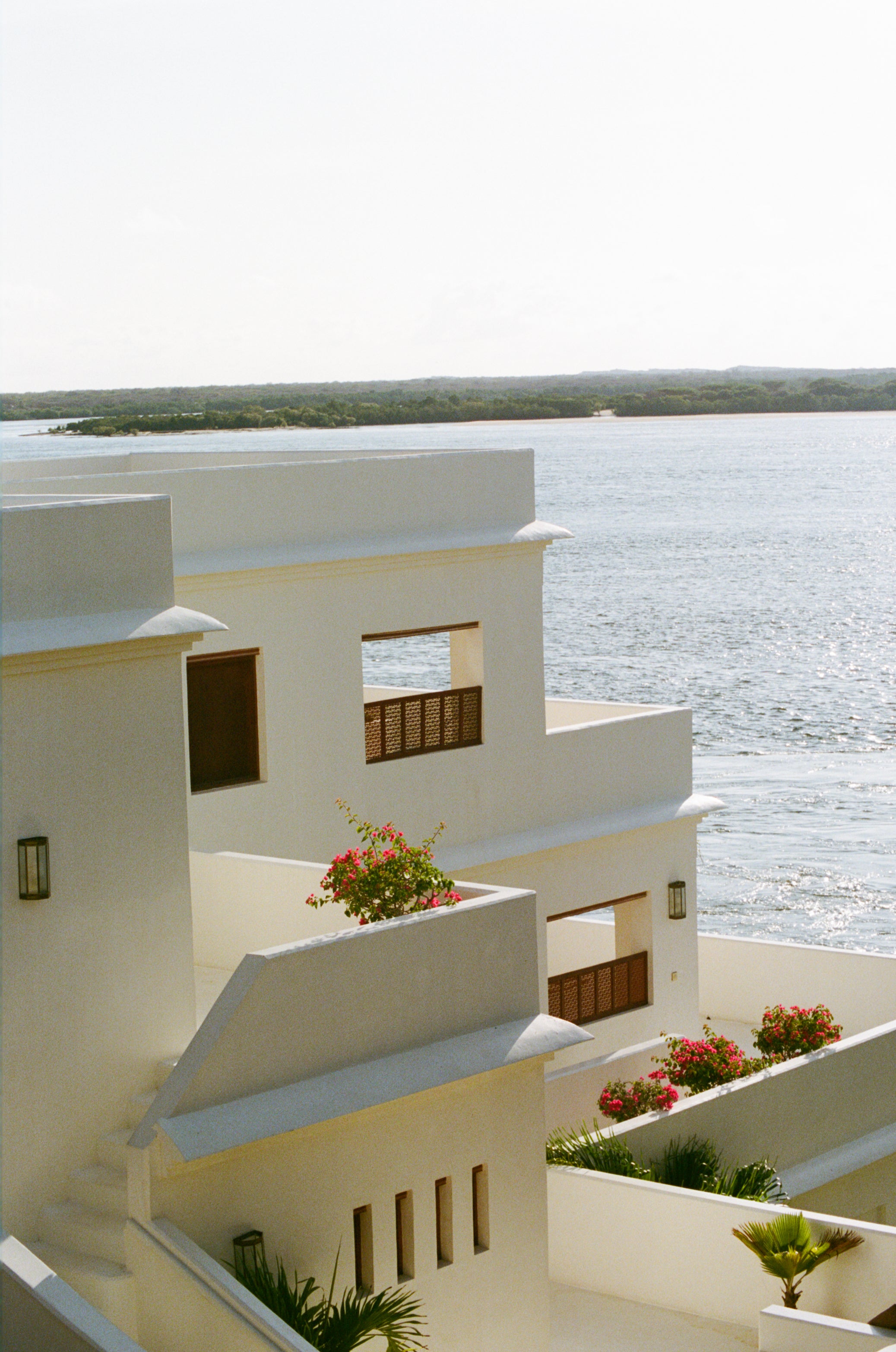 White building with balconies overlooking a body of water shot on 120mm in lamu Kenya
