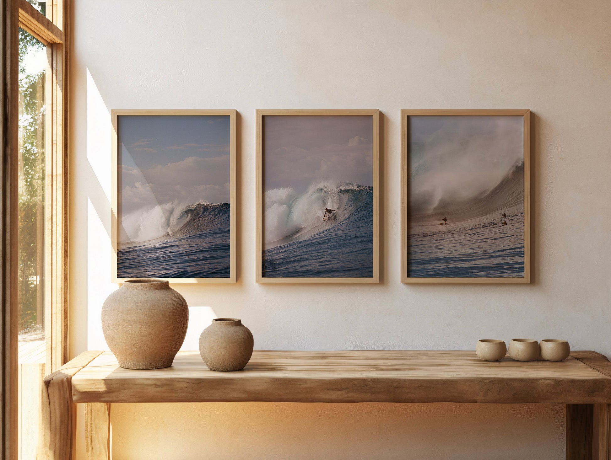 Analog ocean wave photography prints set of three featuring breaking surf and surfer, shot on 35mm film, displayed in wooden frames in a warm minimalist interior