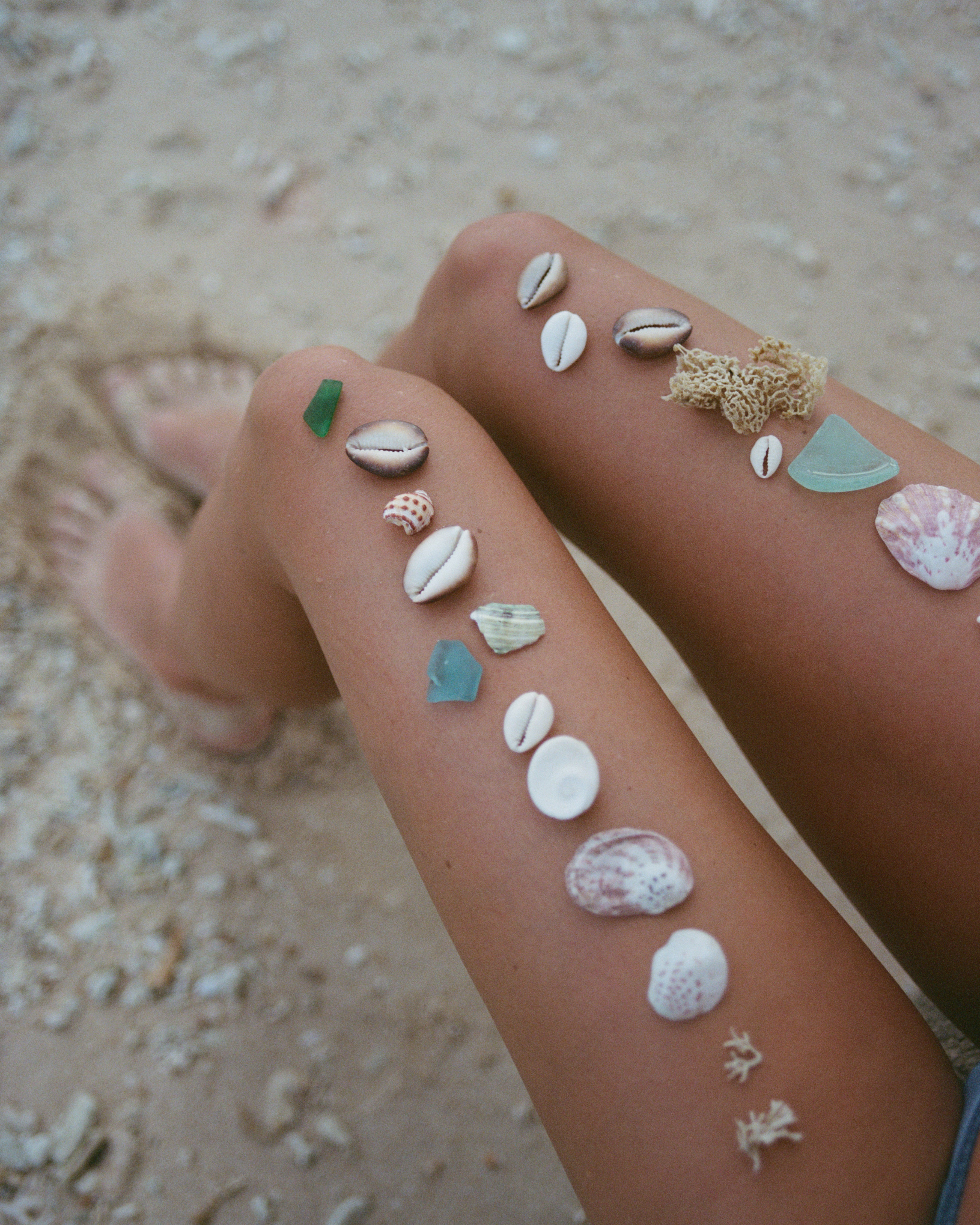 Shells on a person's legs with a sandy background mentawais 120mm film