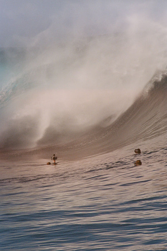 Analog ocean wave print of Teahupo’o with photographers in the water capturing breaking surf, shot on 35mm film with warm cinematic tones